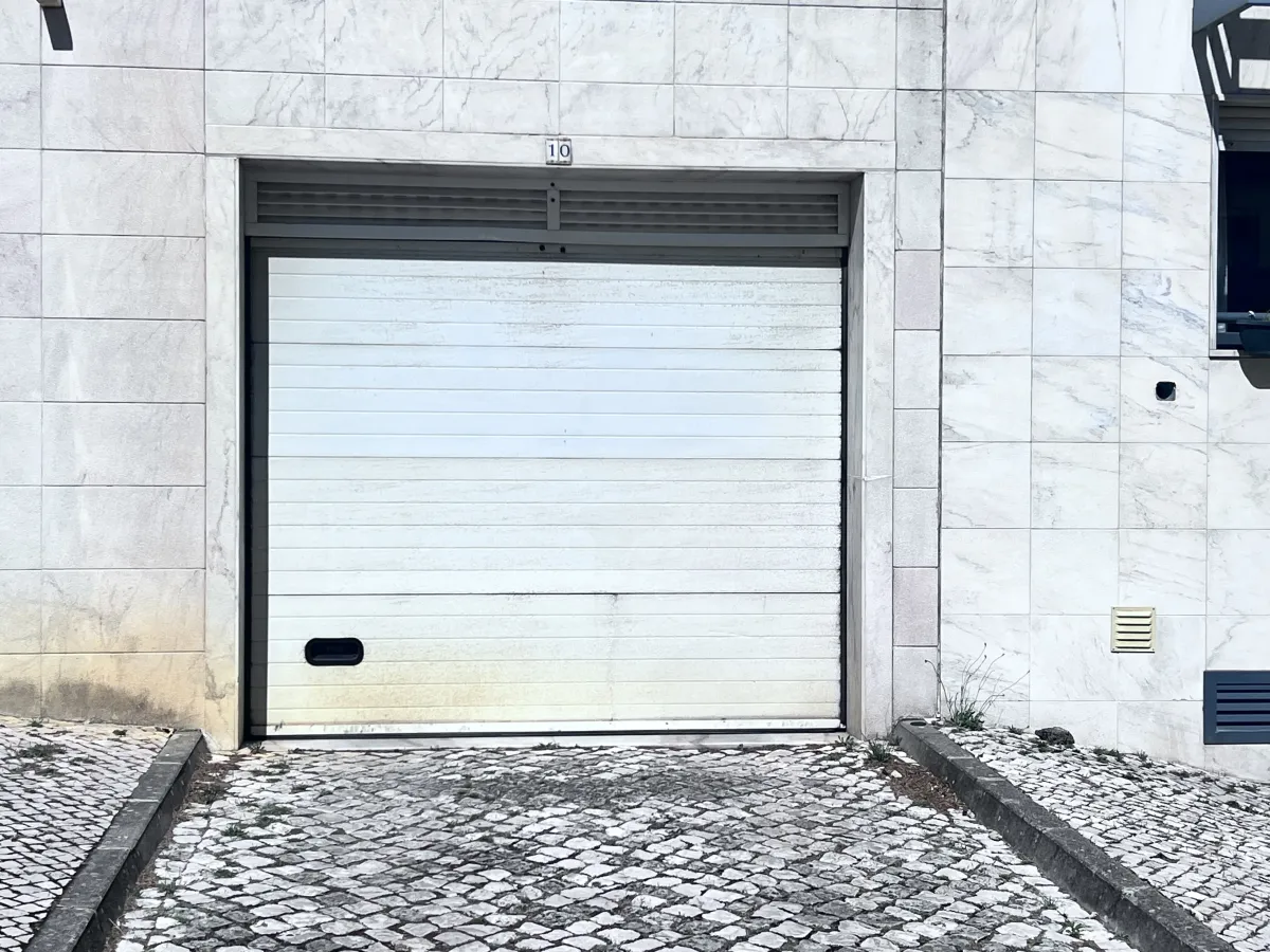 Exterior do portão seccional de garagem após reparação da mola em Caneças, Sintra