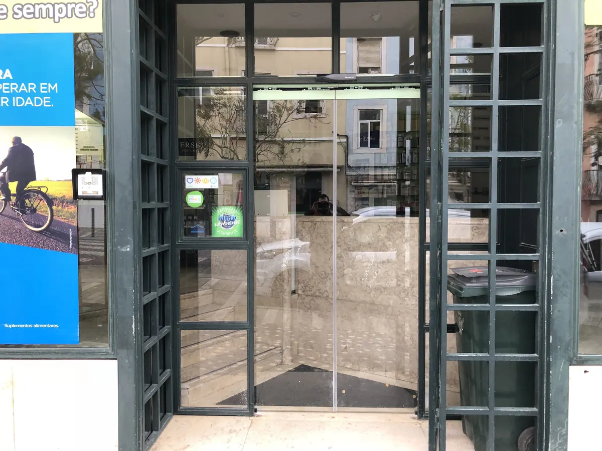 Operador automático instalado em porta clássica de ferro e vidro em loja na Ajuda, Lisboa — foto 2