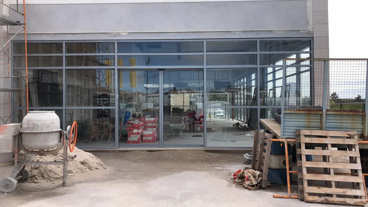 Porta automática deslizante em fachada de vidro de edifício comercial nas Caldas da Rainha