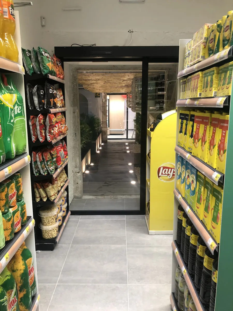 Porta automática interior de perfis pretos entre loja e galeria em Lisboa
