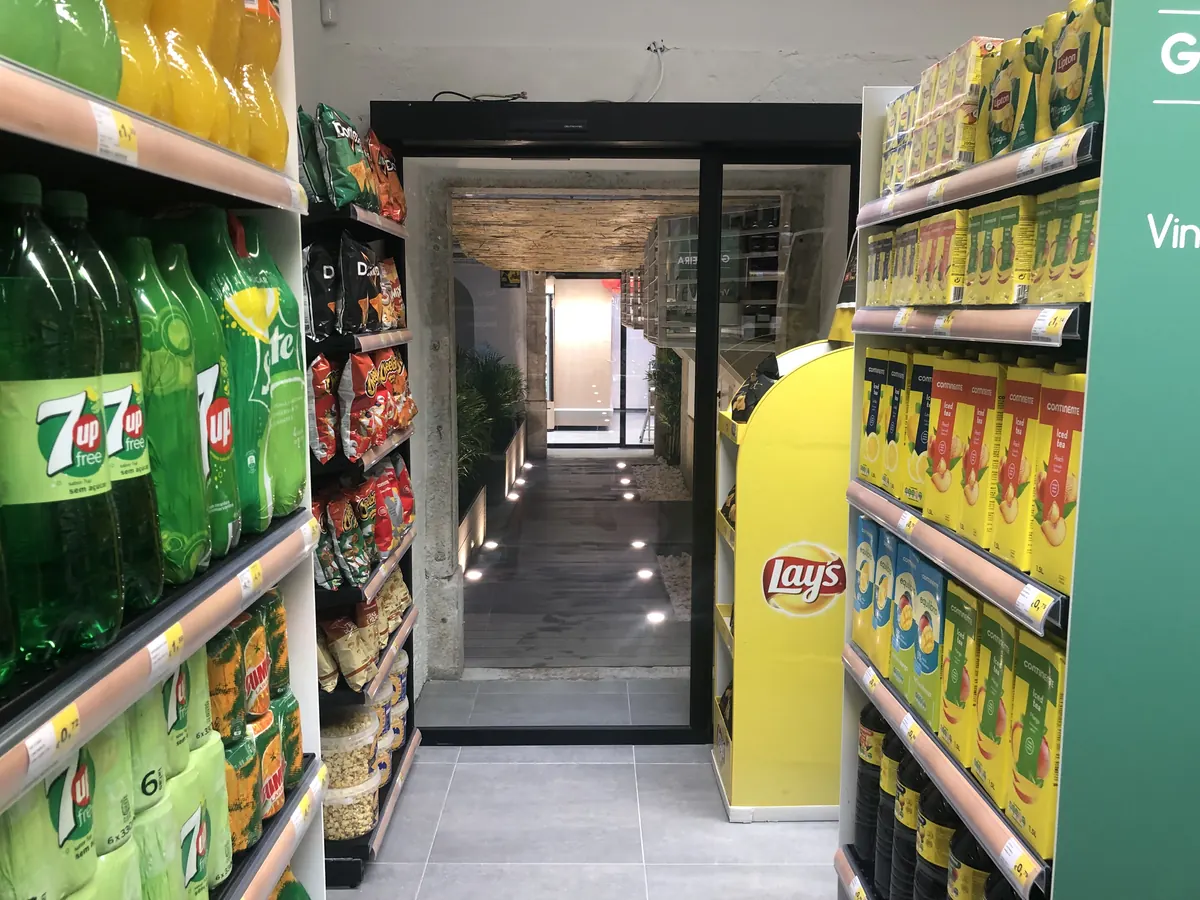 Porta automática interior de perfis pretos entre loja e galeria em Lisboa — foto 2