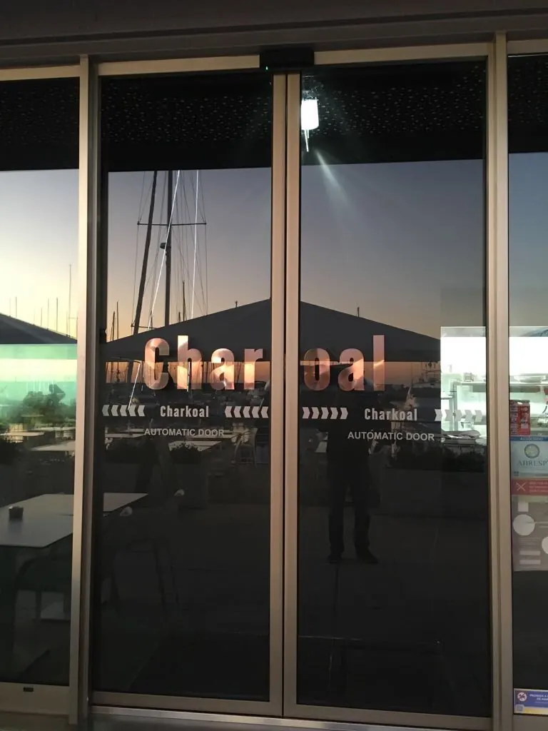 Porta automática de vidro com perfis champanhe em restaurante junto à marina de Oeiras