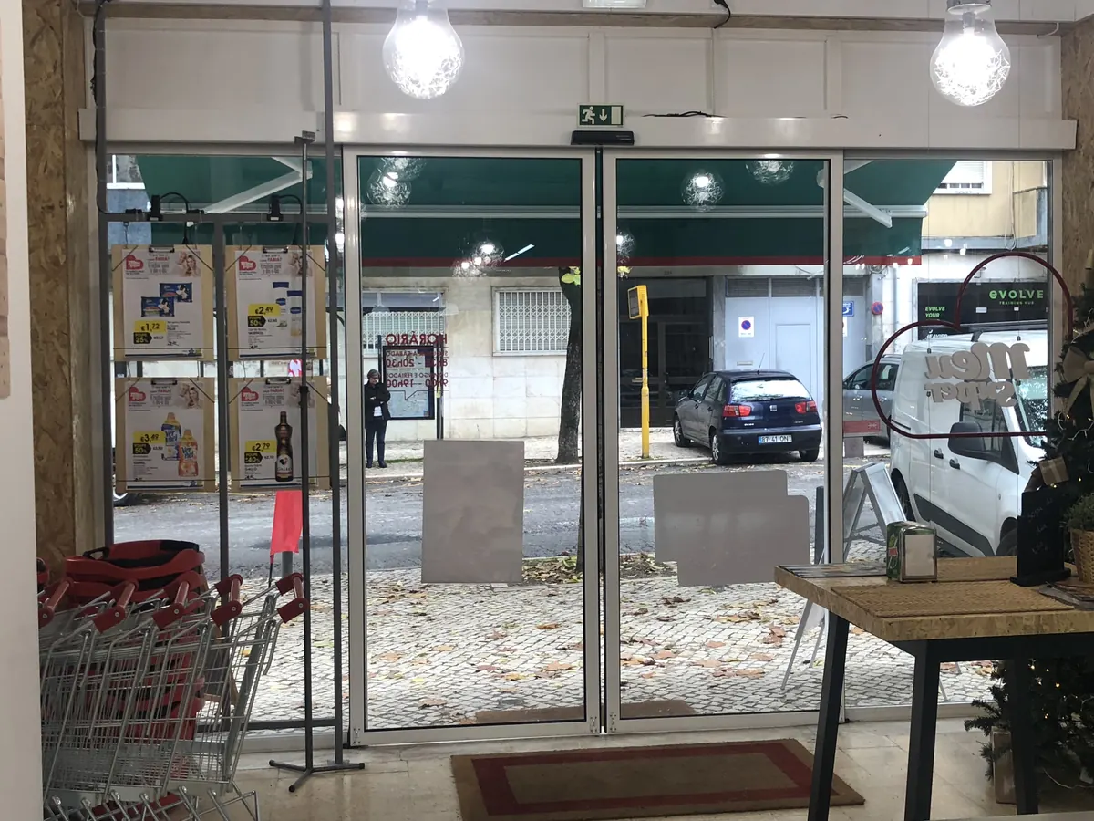 Porta automática deslizante com perfis pretos em supermercado de bairro em Benfica, Lisboa — foto 3