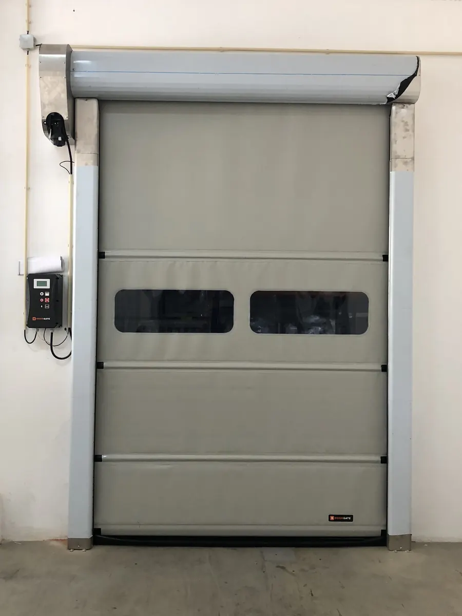 Porta rápida de lona cinzenta com visores num pavilhão industrial em Odivelas
