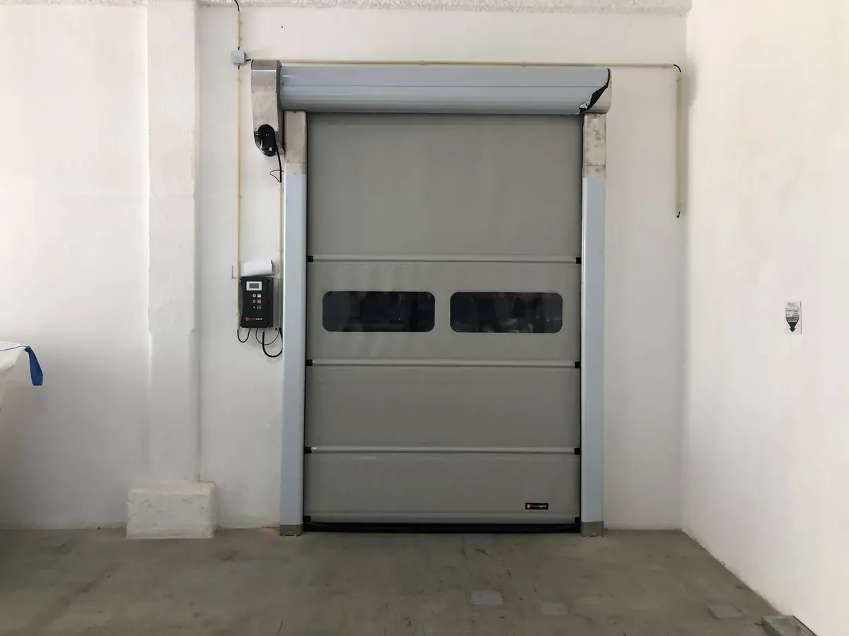 Porta rápida de lona cinzenta com visores num pavilhão industrial em Odivelas — foto 2