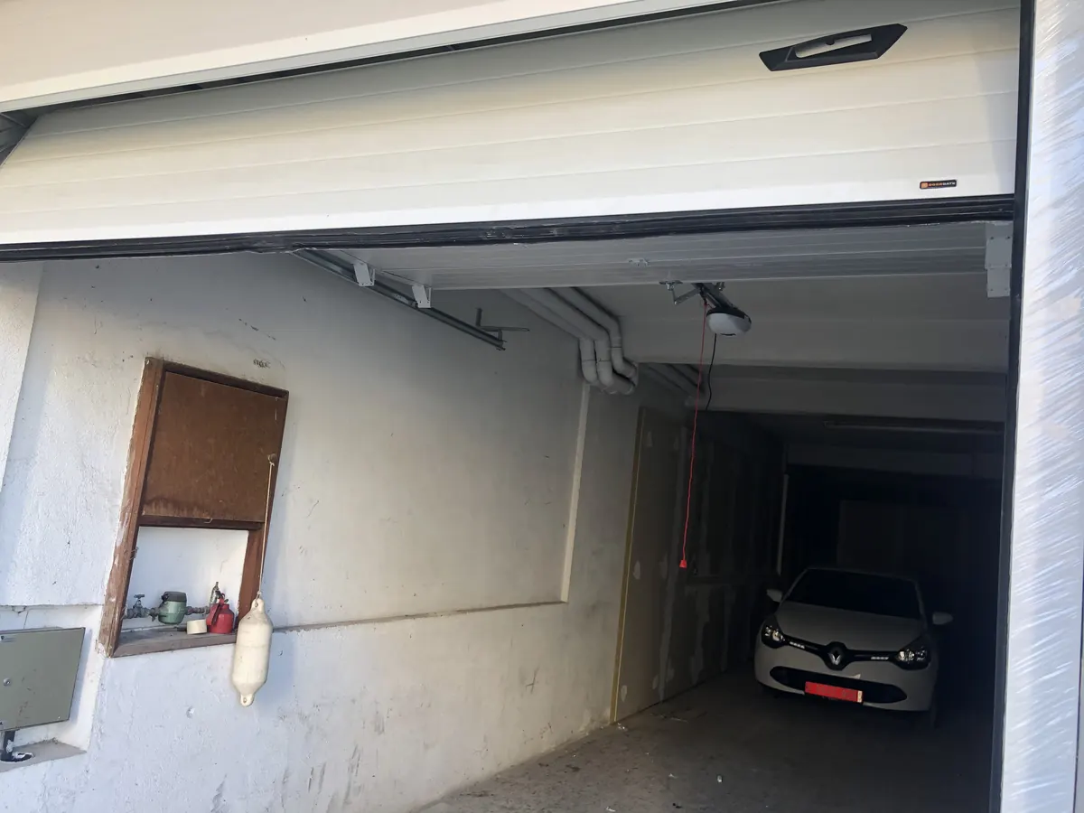 Portão seccional branco com automatismo de teto em garagem de moradia em Agualva-Cacém, Sintra