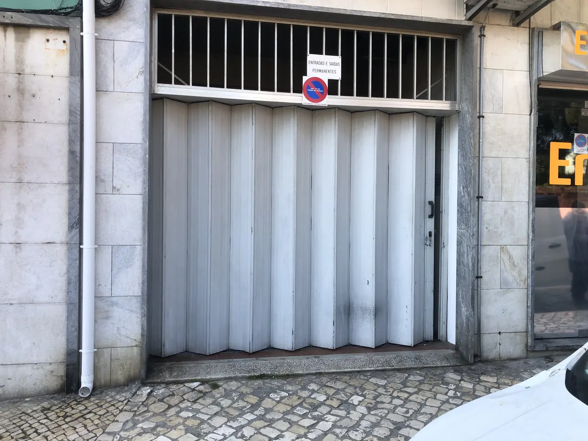 Portão seccional cinza motorizado em substituição de fole antigo em Alcântara, Lisboa — foto 2