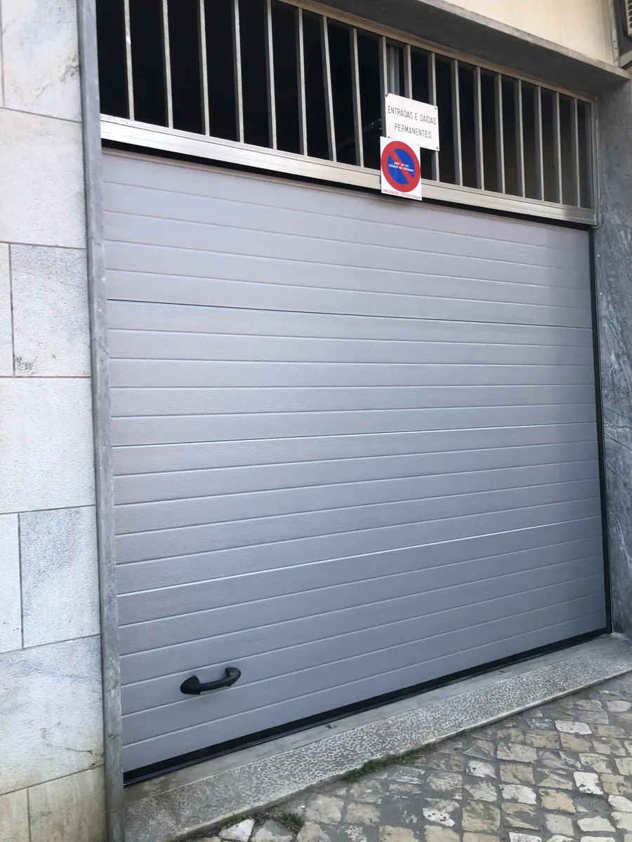 Portão seccional cinza motorizado em substituição de fole antigo em Alcântara, Lisboa — foto 3