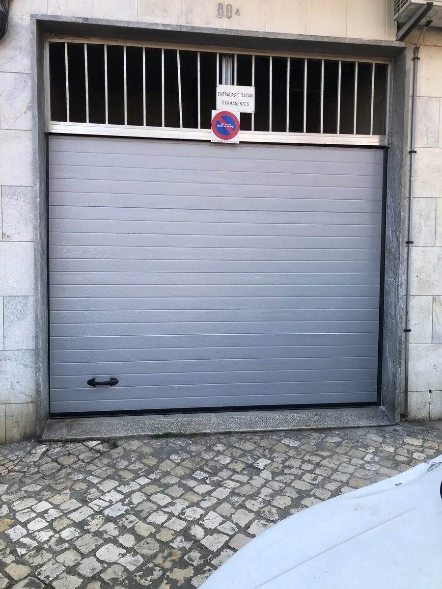 Portão seccional cinza motorizado em substituição de fole antigo em Alcântara, Lisboa — foto 4