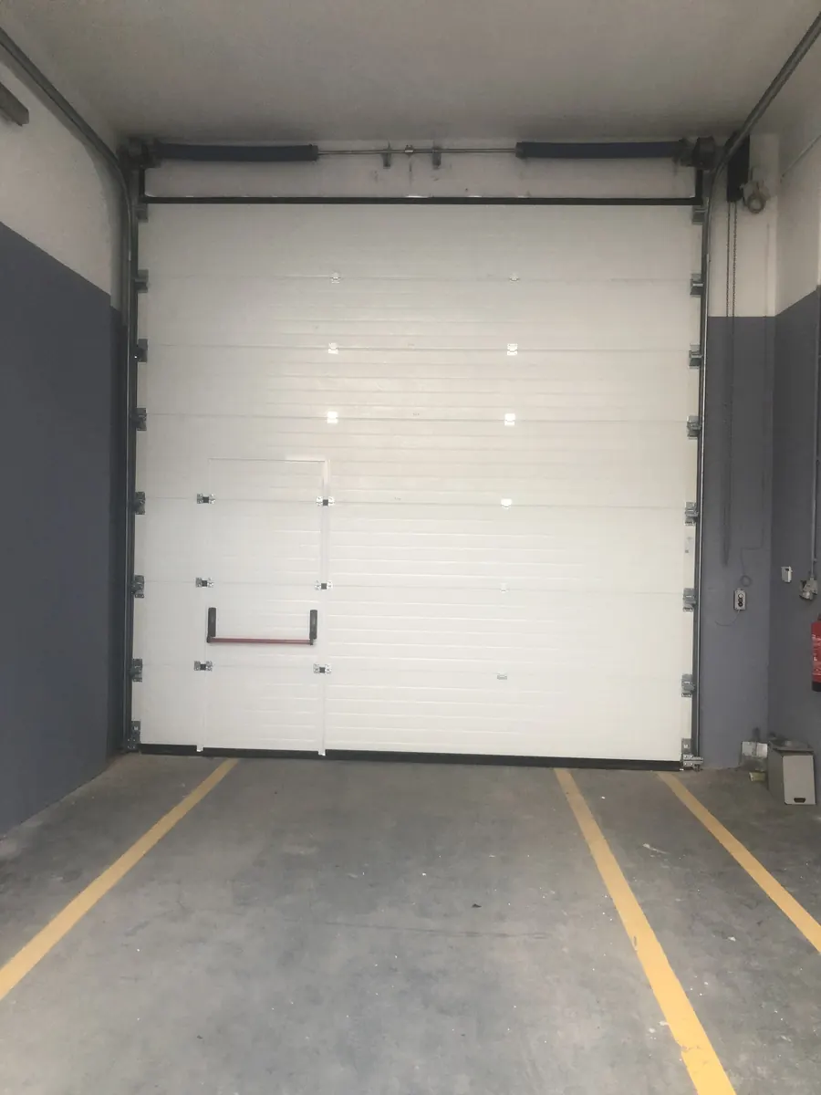 Portão seccional industrial branco com porta de serviço em armazém na Abrunheira, Sintra — foto 4