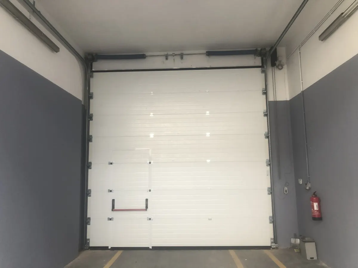 Portão seccional industrial branco com porta de serviço em armazém na Abrunheira, Sintra — foto 5