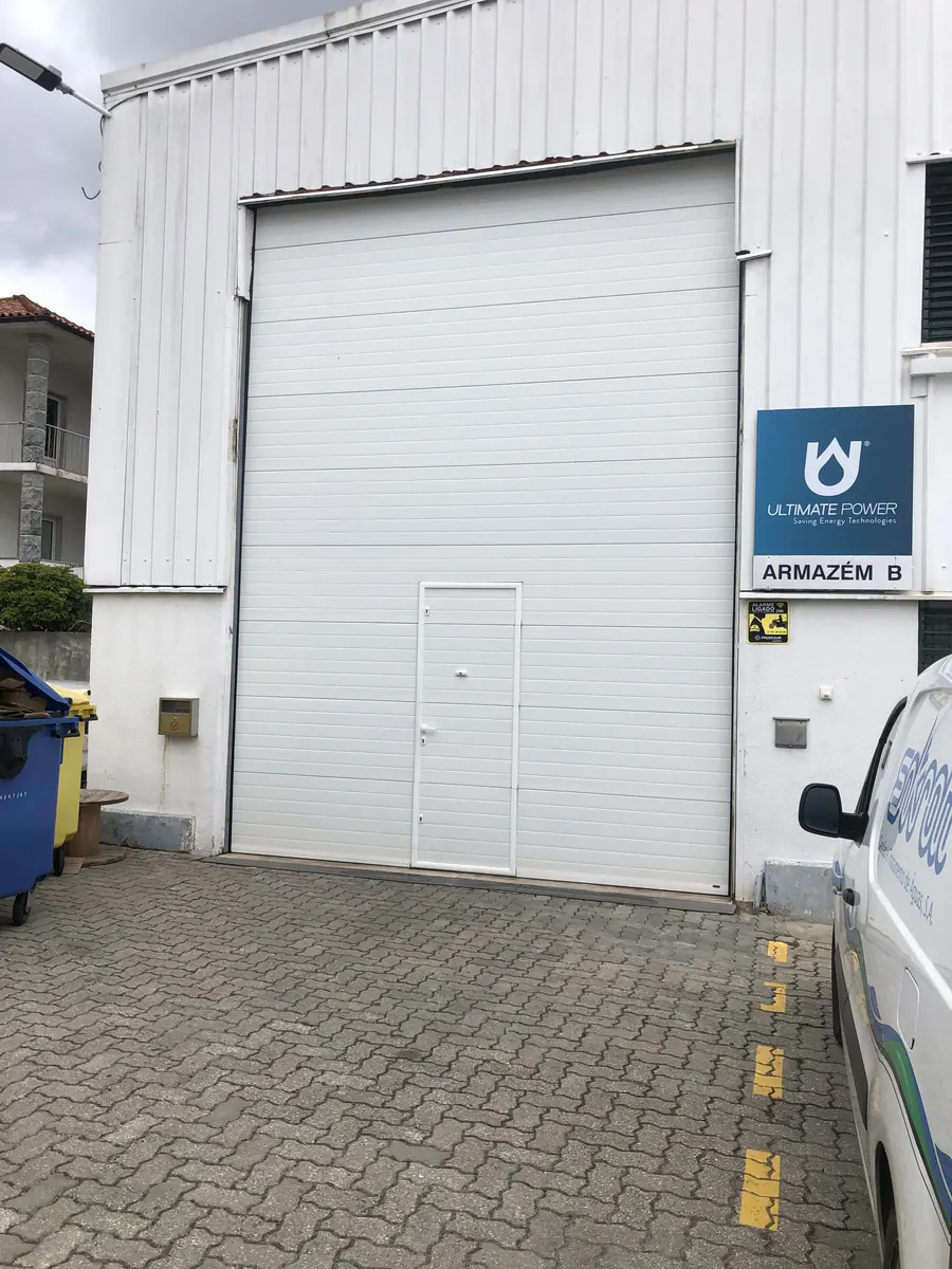 Portão seccional industrial branco de grande altura com porta de serviço em São Domingos de Rana, Cascais