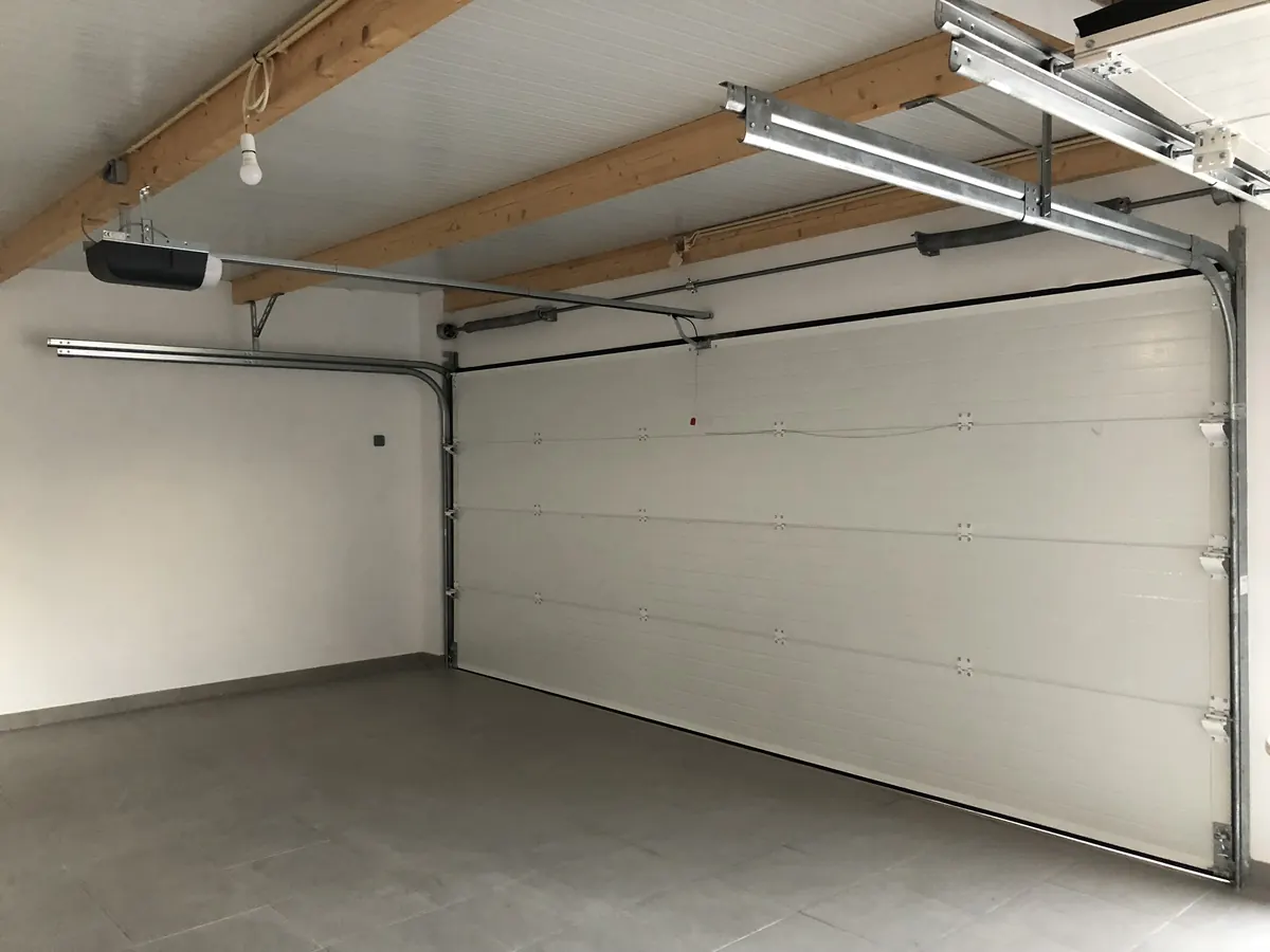 Portão seccional branco com motor SEIP TM60 em garagem de moradia em Carmões, Torres Vedras