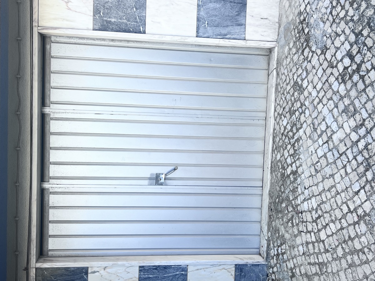 Portão antigo de garagem antes da substituição em moradia em Mem Martins, Sintra