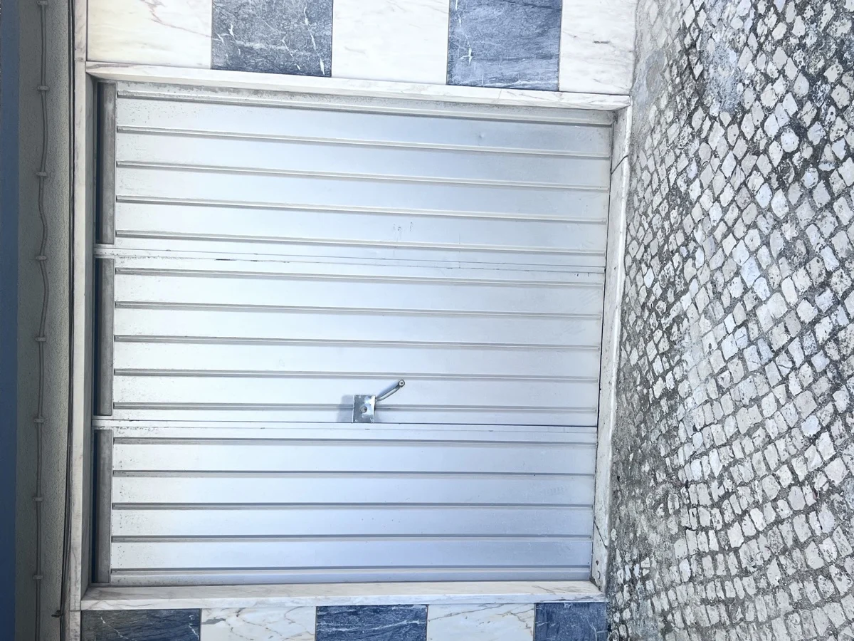 Portão antigo de garagem antes da substituição em moradia em Mem Martins, Sintra