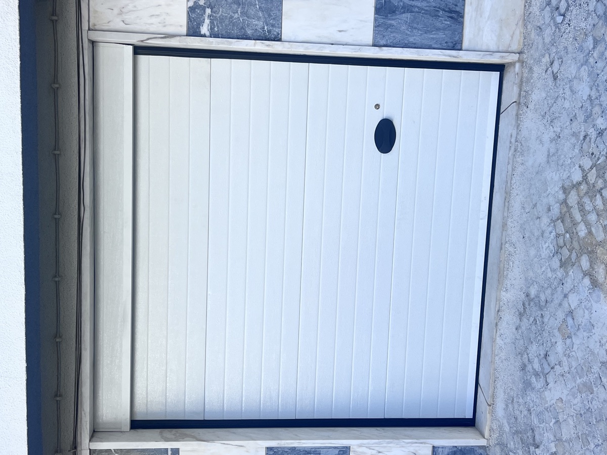 Portão seccional branco instalado em moradia em Mem Martins, Sintra
