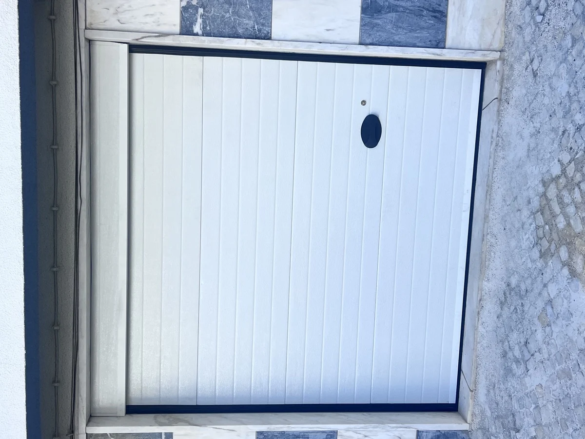 Portão seccional branco instalado em moradia em Mem Martins, Sintra
