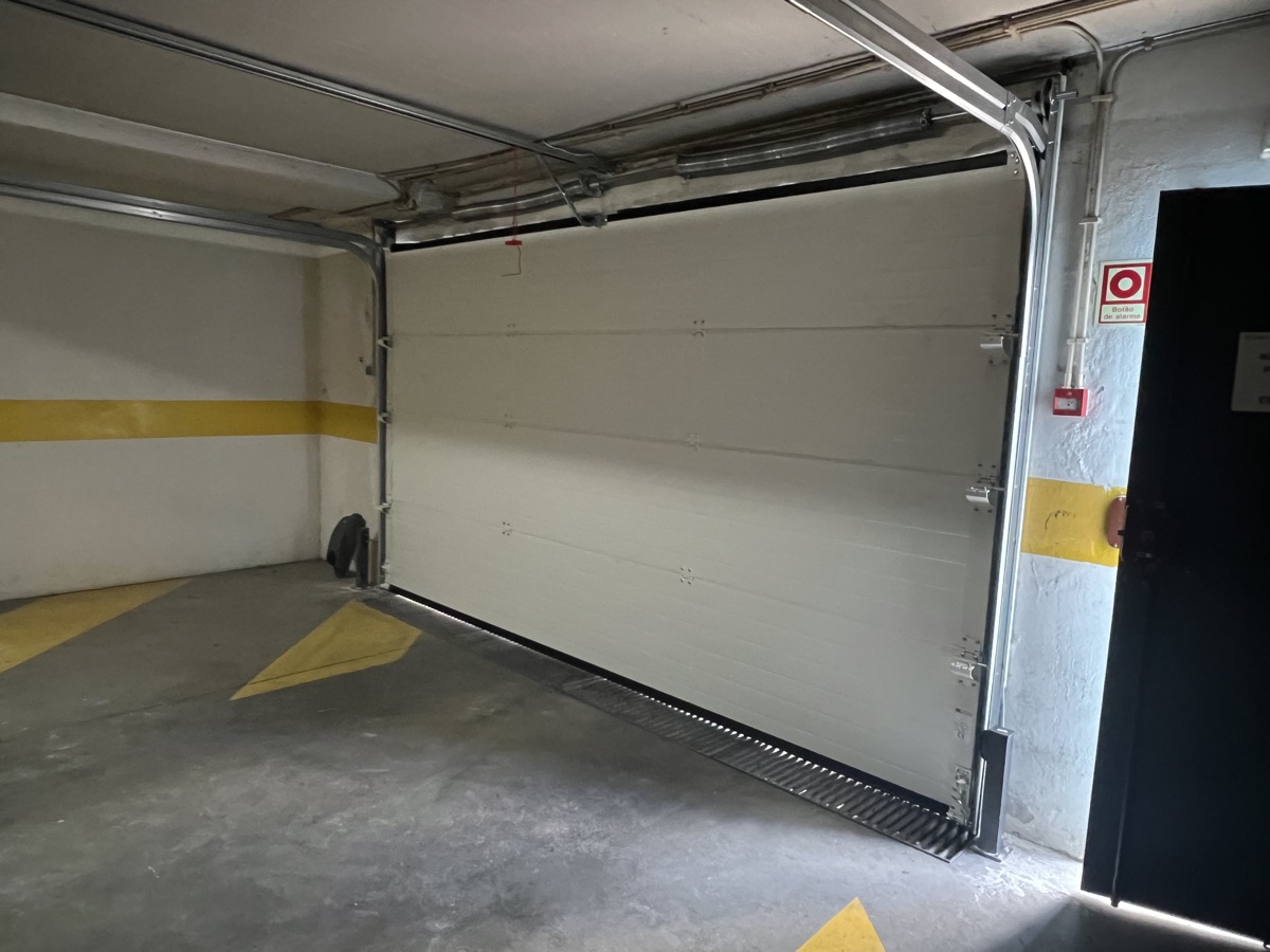 Novo portão seccional fechado visto do interior da garagem após instalação no Parque das Nações
