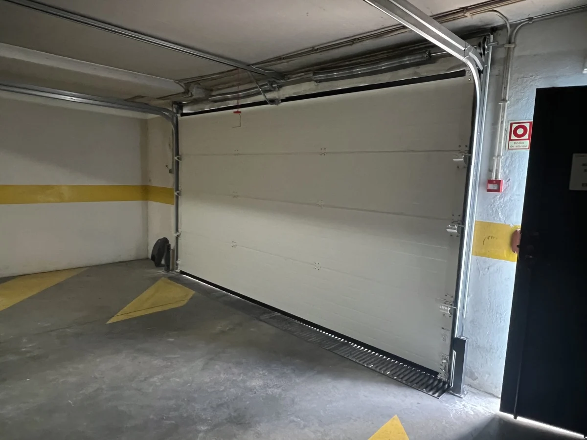 Novo portão seccional fechado visto do interior da garagem após instalação no Parque das Nações