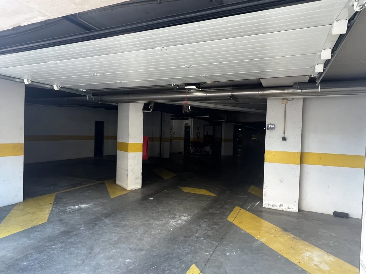 Portão seccional novo aberto mostrando o interior da garagem coletiva no Parque das Nações