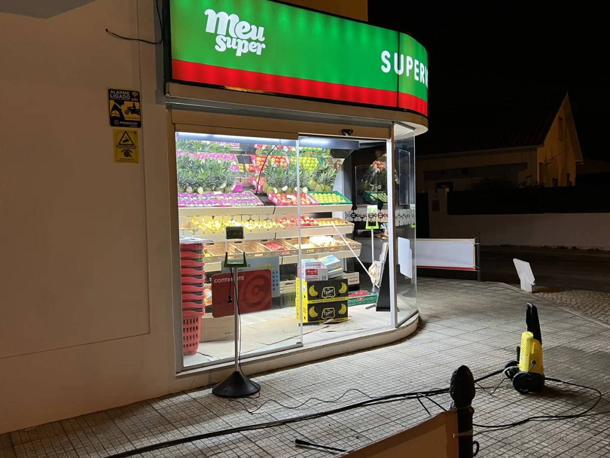 Porta automática de vidro na entrada de um supermercado ao fim do dia