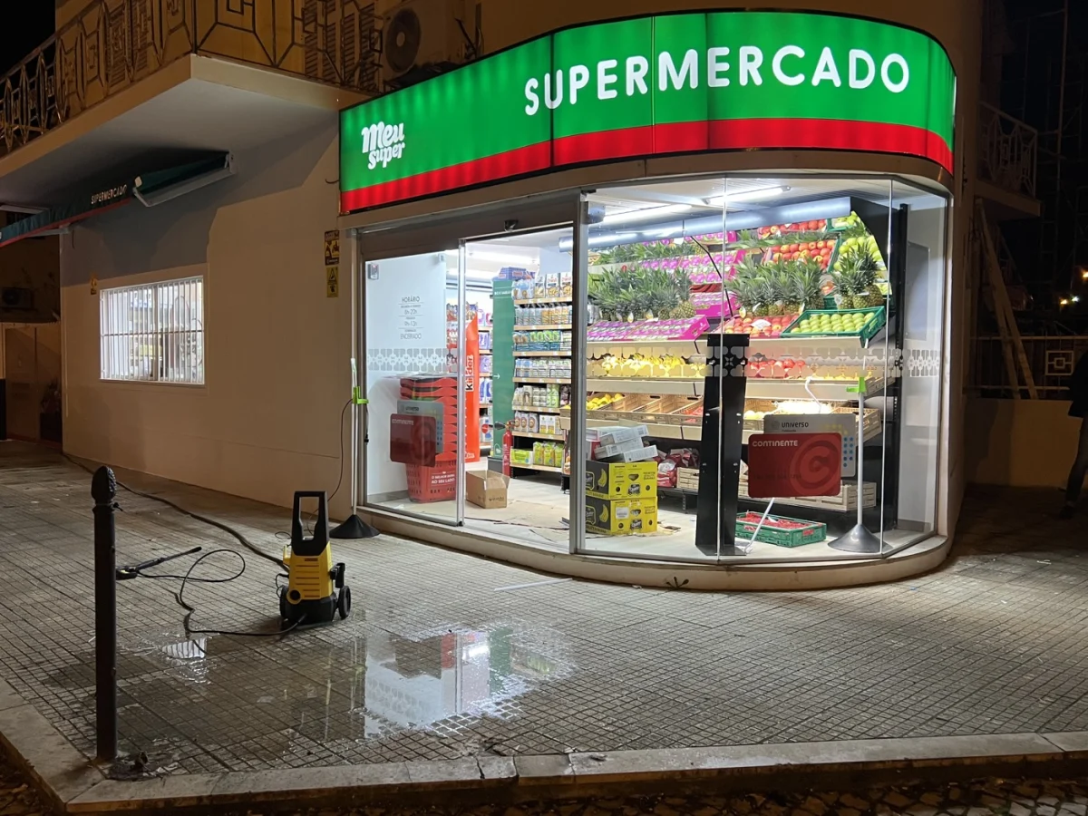 Entrada curva em vidro de supermercado com porta automática iluminada