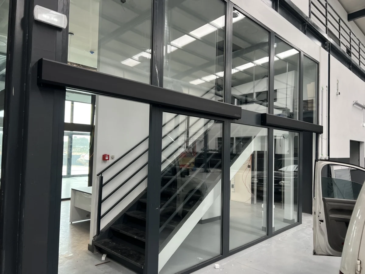 Porta automática de vidro com perfil escuro em átrio interior
