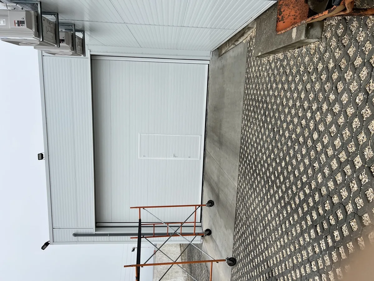 Portão de garagem em montagem, com andaime junto ao vão